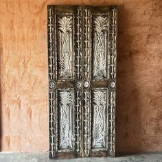 an old metal door in front of a stucco wall