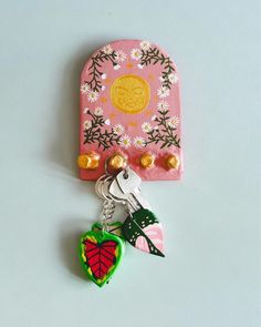 a keychain with a flowered design on it and a heart shaped charm attached to it