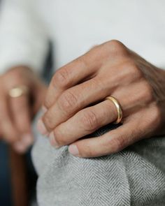 a person with two gold rings on their fingers and one is wearing a white shirt