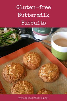 gluten - free buttermilk biscuits on a baking sheet next to a cup of coffee