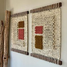 two woven wall hangings are on the wall