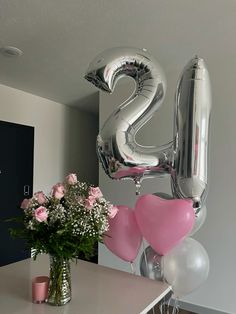 a vase filled with flowers and balloons in front of the number twenty two balloon sculpture