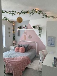 a bedroom decorated in pink, grey and white with greenery on the wall above the bed