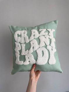 someone is holding up a pillow that says crazy and glad on the front in white