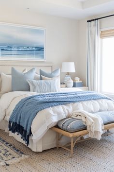 a bedroom with a large bed covered in blue and white blankets