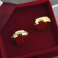 two gold rings sitting in a red velvet box