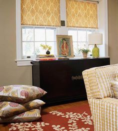 a living room filled with furniture next to a window covered in yellow and white curtains