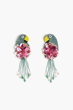 two pairs of bird shaped earrings with flowers and beads on each earring, one is green