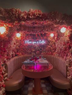 a booth with flowers and lights on the walls, along with two booths for seating