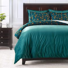 a bed with green comforter and matching pillows