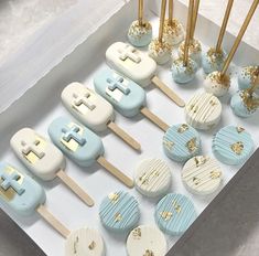 a box filled with blue and white cupcakes on top of wooden skewers