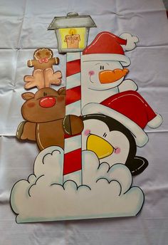 a paper cut out of a snowman and penguin with a lamp post on top