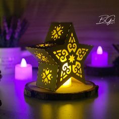 a lit up star shaped candle holder sitting on top of a table