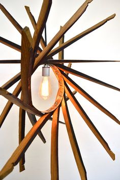 a light bulb is hanging from a wooden sculpture made out of sticks and wood planks