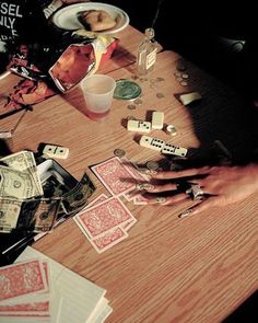 a table topped with lots of playing cards and dice on top of wooden flooring