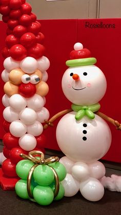 two snowmen are standing next to each other with balloons in the shape of them