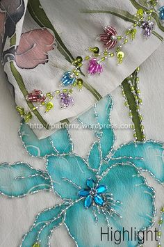 the fabric has been sewn together with beaded flowers and beads on it's sides