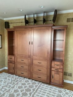 a large wooden cabinet sitting in the middle of a living room next to a rug