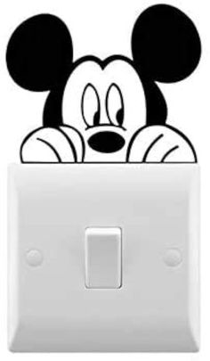 the mickey mouse light switch cover is white and has a black face on it's head