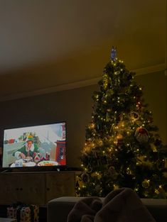 a living room with a christmas tree and television