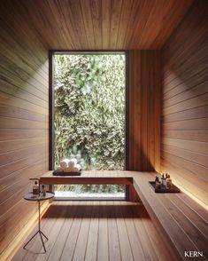 the inside of a sauna with wooden walls and flooring, looking out onto trees