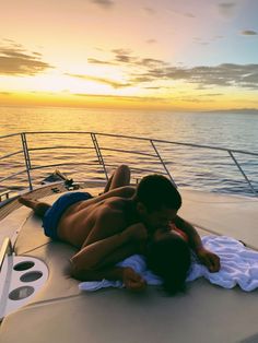 two people laying on the back of a boat