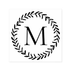 a black and white monogramed wreath with the letter m in it's center