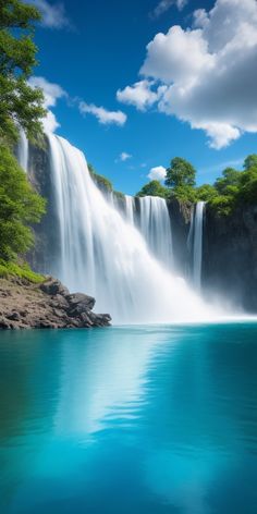 a large waterfall that is next to a body of water with trees in the background