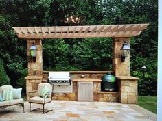 an outdoor kitchen with grill and seating area