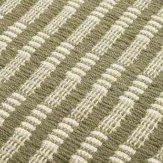 a close up view of the texture of a rug with green and white stripes on it