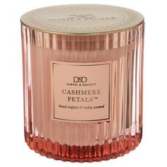 a pink candle that is sitting on top of a white surface with the words cashmere petals