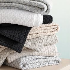 a stack of towels sitting on top of a wooden table