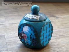 a blue ceramic container with an image of a fish on the lid and words underneath it