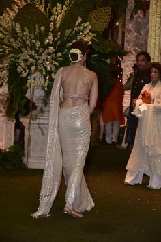 the back of a woman's dress in front of people at a wedding ceremony