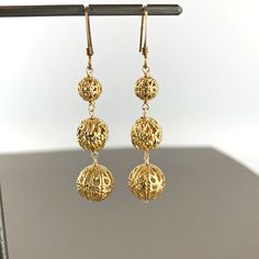 "Filigree Earrings, Gold Plated Earrings ,Lace Earrings,Boho Earrings, Hippie Earrings, Vintage Earrings, Dangle Earrings, Drop Earrings A departure from our traditional \"Daniela\" style, these triple filigree golden bead drop earrings are for when a little extra glitz is needed. When you wear these, the shimmering filigree beads cast a luminous glow on all of your special occasions. Filigree Beads are hand wrapped with wire connecting each piece to the ear wire. These are our favorite go to ea Ear Wire Drop Earrings For Jewelry Making, Gold Plated Long Drop Pierced Earrings, Gold Plated Long Drop Earrings, Adjustable Filigree Dangle Earrings, Brass Filigree Dangle Earrings, Metal Filigree Drop Earrings, Pierced Drop Earrings As A Gift, Pierced Dangle Earrings As Gift, Gold Long Drop Earrings For Pierced Ears