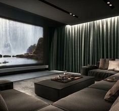 a living room with two couches and a large screen on the wall behind them