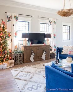 a living room decorated for christmas with blue couches