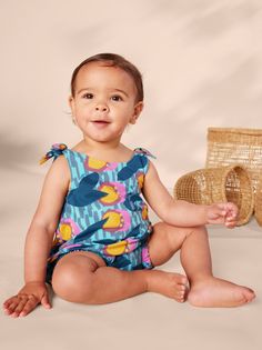 From our Kenya collection, this adorable printed romper is made of super lightweight and breathable 100% soft cotton jersey that will keep its color and shape, wash after wash. Features adjustable shoulder ties, inseam snaps, and elastic leg openings for easy dressing and diaper changes. Falls at mid-thigh. Multicolor Cotton Bodysuit For Playtime, Multicolor Cotton Playtime Bodysuit, Casual Cotton Bubble Romper For Beach, Playful Multicolor Cotton Bodysuit, Summer Cotton Bubble Romper For Loungewear, Playful Cotton Jumpsuits And Rompers For Vacation, Playful Printed Sleeveless Jumpsuits And Rompers, Playful Cotton Bodysuit For Playdate, Playful Cotton Jumpsuits And Rompers For Beach