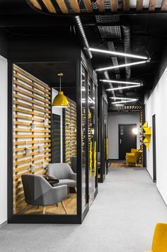 an office with black walls and yellow accents on the ceiling, along with gray chairs