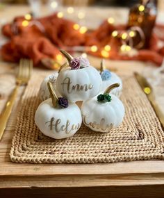 three white pumpkins sitting on top of a place mat