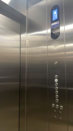 an elevator with stainless steel doors and buttons