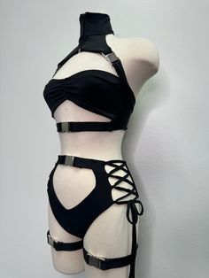 Introducing the Dakota Set, a stunning festival suit that's sure to turn heads wherever you go! This one-of-a-kind rave bodysuit features a unique design making it a true statement piece. The set is designed with leg buckles, adding a touch of edginess to the overall look. Made with high-quality materials, the Dakota Set is comfortable to wear and durable enough to withstand all your festival adventures.This festival outfit is available in XS-4X sizes, making it a versatile option for all body t Edgy Black Harness For Festivals, Fitted Strapped Harness For Party, Fitted Punk Harness For Alternative Fashion, Black Punk Harness For Festival, Black Punk Style Festival Harness, Edgy Fitted Harness For Alternative Fashion, Adjustable Strapped Party Harness, Fitted Gothic Harness For Cosplay, Adjustable Strapped Harness For Party