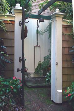 an outdoor shower surrounded by plants and flowers