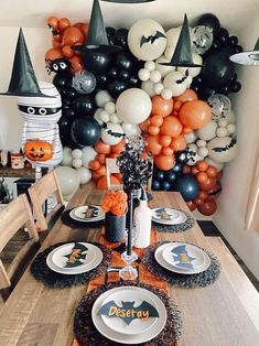 a dining room table decorated for halloween with balloons and decorations