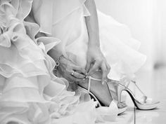 black and white photo of woman in high heeled shoes with ruffled skirt on the floor