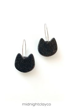 the black earrings are hanging from silver hooks