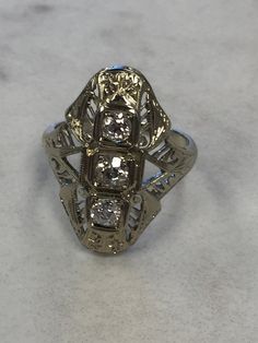 14kt White Gold Lady's Art Deco Vintage Diamond Ring consisting of 3 Old Miner European Cut Diamonds .65ct total weight all prong set incased in hand designed box styling with wonderful and unique pattern of elegance and sophistication. This ring is vintage from the 1920's and would be adorned by the person who wears it. This ring is a size 6. This item would Retail for $2,990.00 Antique Three Stone Diamond Ring For Formal Occasions, Antique Three Stone Round Diamond Ring, Antique Three Stone Diamond White Rings, Antique Three-stone Diamond White Rings, Antique Three Stone Diamond Ring In Diamond White, Collectible 14k Gold Diamond Ring, Antique Three Stone Diamond Ring, Antique Oval Three Stone Diamond Ring, Antique Platinum Three Stone Diamond Ring