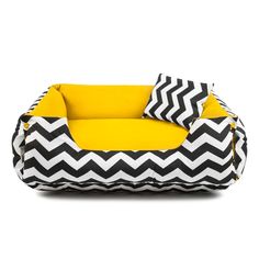 a black and white chevroned dog bed with yellow pillows on the bottom half