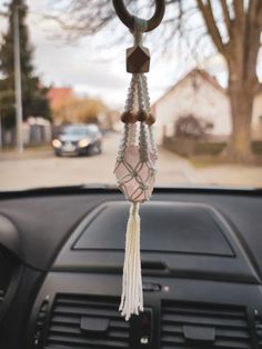 a car dashboard with a steering wheel hanging from it's center console, in front of a house