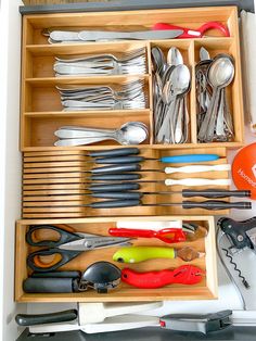 an organized drawer with utensils and spoons in it, including forks and knives